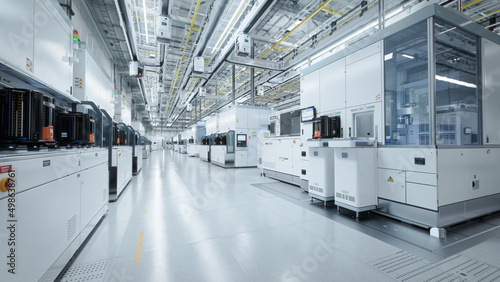 Wide Shot of Bright Advanced Semiconductor Production Fab Cleanroom with Working Overhead Wafer Transfer System 