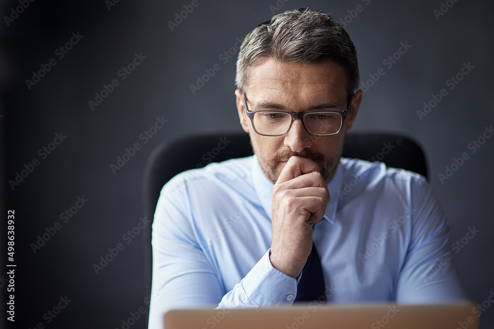 He never acts without thought. Cropped shot of a mature businessman working in his office. He never acts without thought. Cropped shot of a mature businessman working in his office.