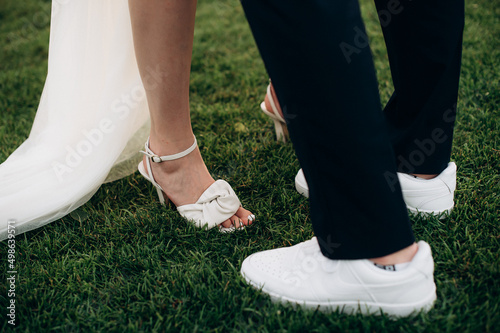 newlyweds stand on the grass  legs close-up
