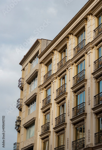 Old historical buildings. Each apart has french balcony. Architectural elements.