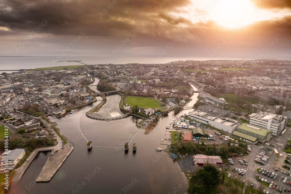 Aerial drone view on Galway city. River Corrib and rowing club. Dark dramatic sunset sky. Nobody. Popular tourist and business city with rich history.