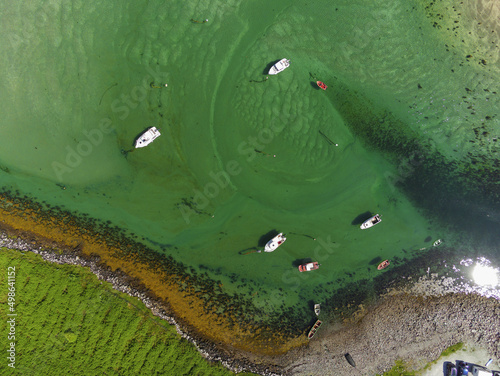Small boats in lagoon. Mulranny town area, county Mayo, Ireland. Aerial drone top down view. Travel and fishing sport concept. Warm sunny day. Irish landscape