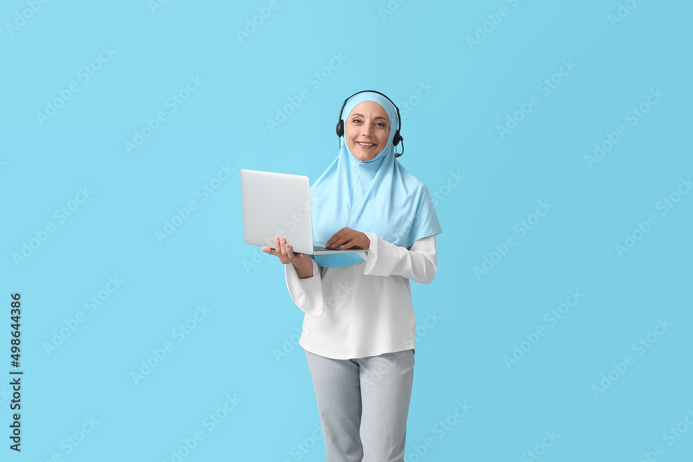 Muslim secretary with headset and laptop on color background Muslim secretary with headset and laptop on color background