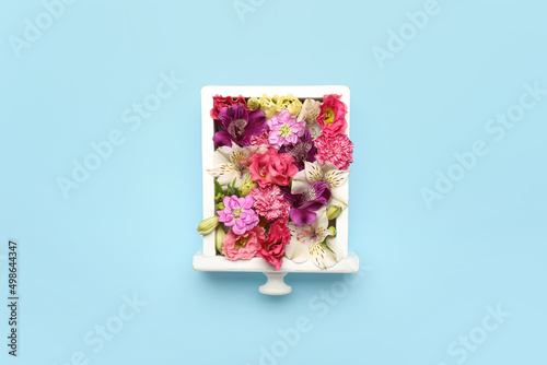 Composition with beautiful flowers and drawer on blue background