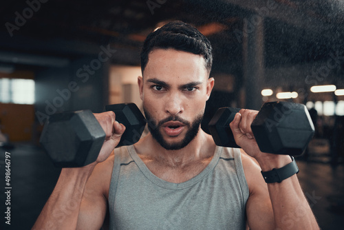 Theres no stopping this train. Shot of a young man using weights in the gym.