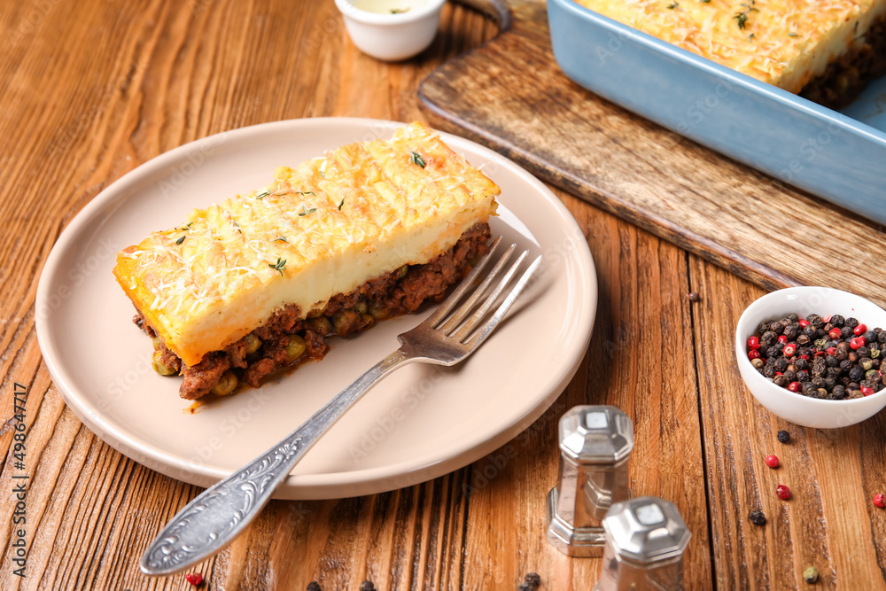 Plate with piece of tasty Shepherd's pie on wooden background Plate with piece of tasty Shepherd's pie on wooden background