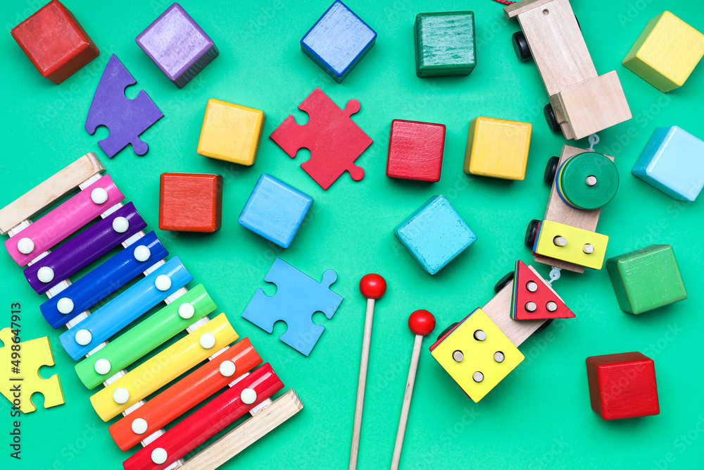 Obraz premium Wooden cubes with puzzle pieces and xylophone on color background