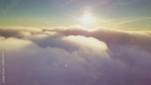 4K Drone flies in the clouds. Flight through the clouds during sunrise, top view of the clouds from the drone. National Park Shipit Karpat. Carpathians, Pylypets, Ukraine.  photo