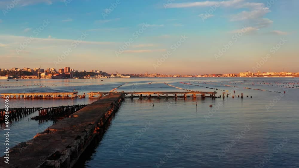 Old pier under Ponte Punta Penna, bridge, at dawn and fisherman with small boat, Taranto Old pier under Ponte Punta Penna, bridge, at dawn and fisherman with small boat, Taranto