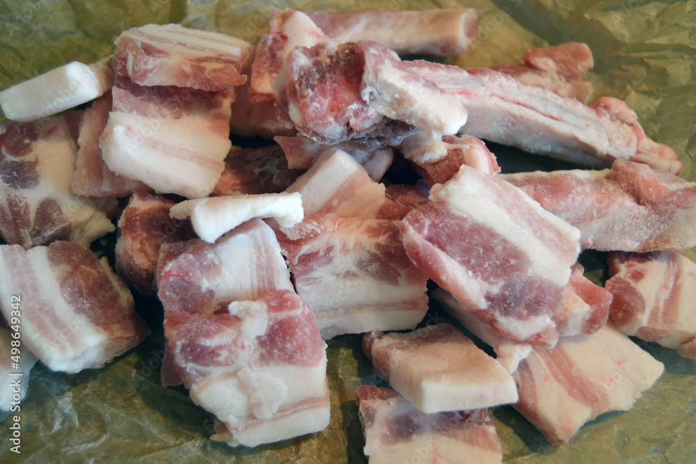 Frozen pieces of fresh raw pork belly meat with white fat and red-pink meat