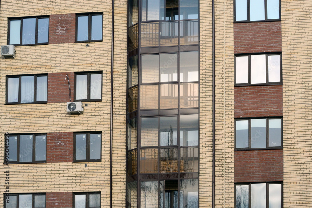 Fototapeta premium New apartment building with glass balconies. Modern architecture houses. Large glazing on the facade of the building.