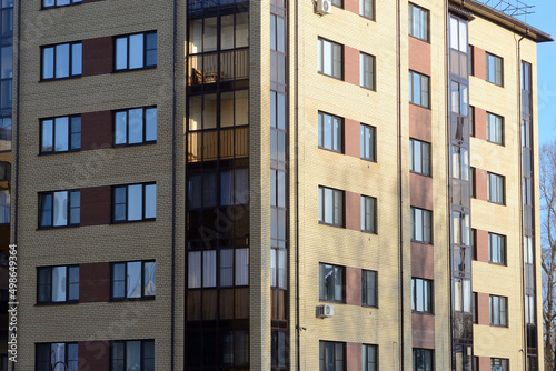 New apartment building with glass balconies. Modern architecture houses. Large glazing on the facade of the building.
