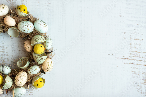 Easter background wreath with Easter eggs and chicks. Top view with copy space.