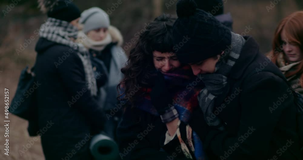 Woman Crying While Fellow Refugees Consoling Her During War.
