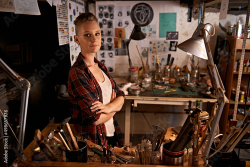 Organized chaos. Shot of a beautiful young woman sitting in a workshop.