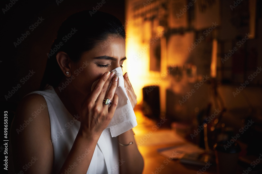 I might need some more tissues. Shot of a young businesswoman blowing her nose while working late in an office. I might need some more tissues. Shot of a young businesswoman blowing her nose while working late in an office.