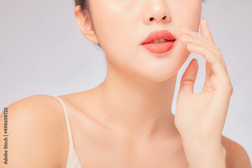 Fototapeta premium A close view of model showing lip posing with hand for cosmetic advertising