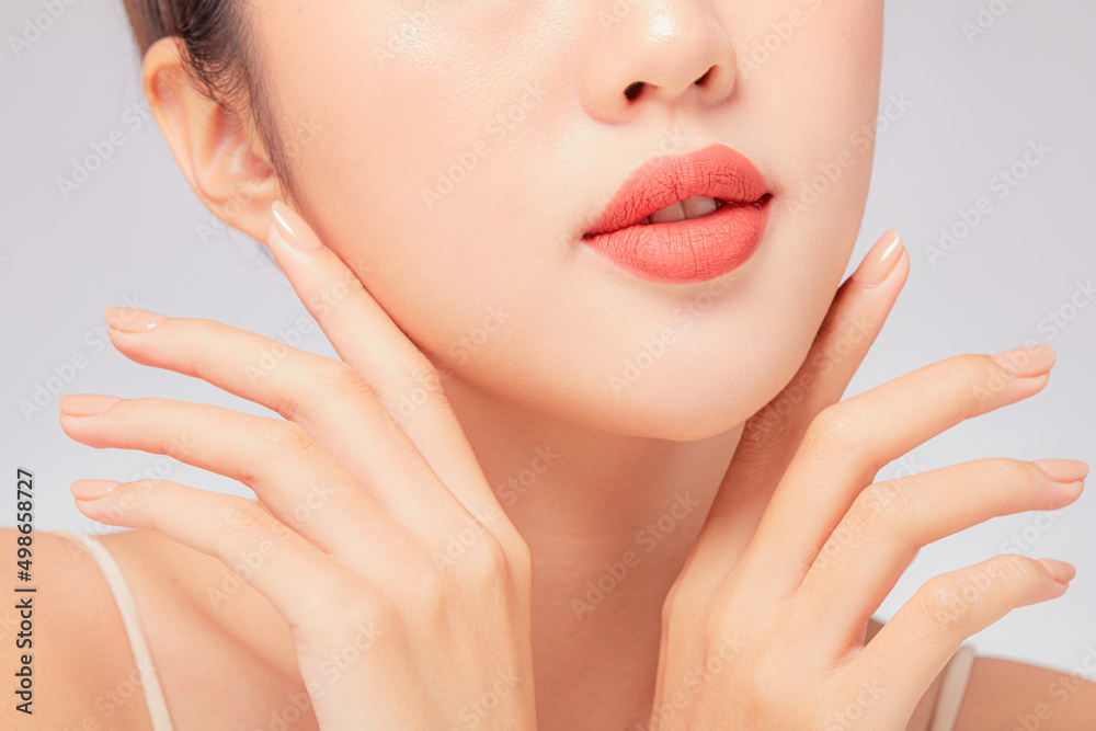A close view of model showing lip posing with hand for cosmetic advertising A close view of model showing lip posing with hand for cosmetic advertising