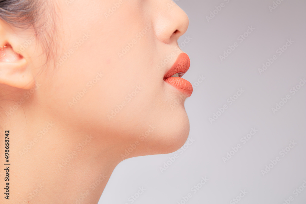 Obraz premium A close view of model showing lip posing with hand for cosmetic advertising