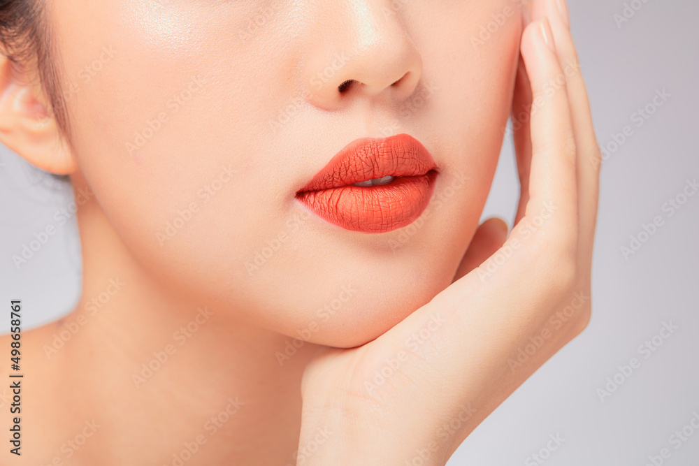 Fototapeta premium A close view of model showing lip posing with hand for cosmetic advertising