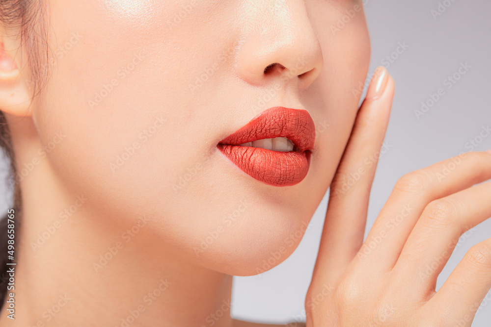 Fototapeta premium A close view of model showing lip posing with hand for cosmetic advertising