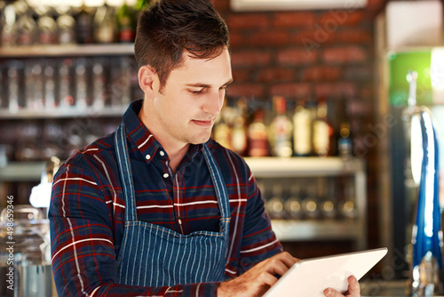 The internet can help you run a profitable business. Cropped shot of a restaurant owner using a digital tablet.