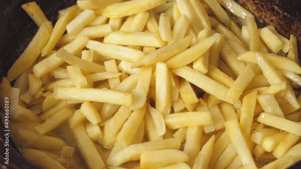 French fries are fried in a frying pan in boiling oil. Close-up French fries are fried in a frying pan in boiling oil. Close-up