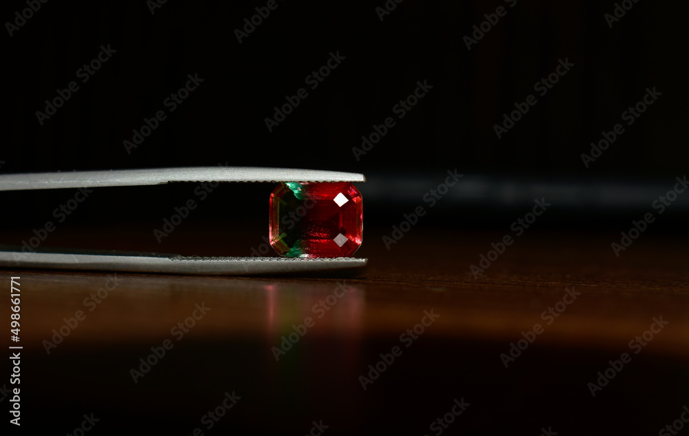 A beautiful red gem or ruby is placed on the ground. A beautiful red gem or ruby is placed on the ground.