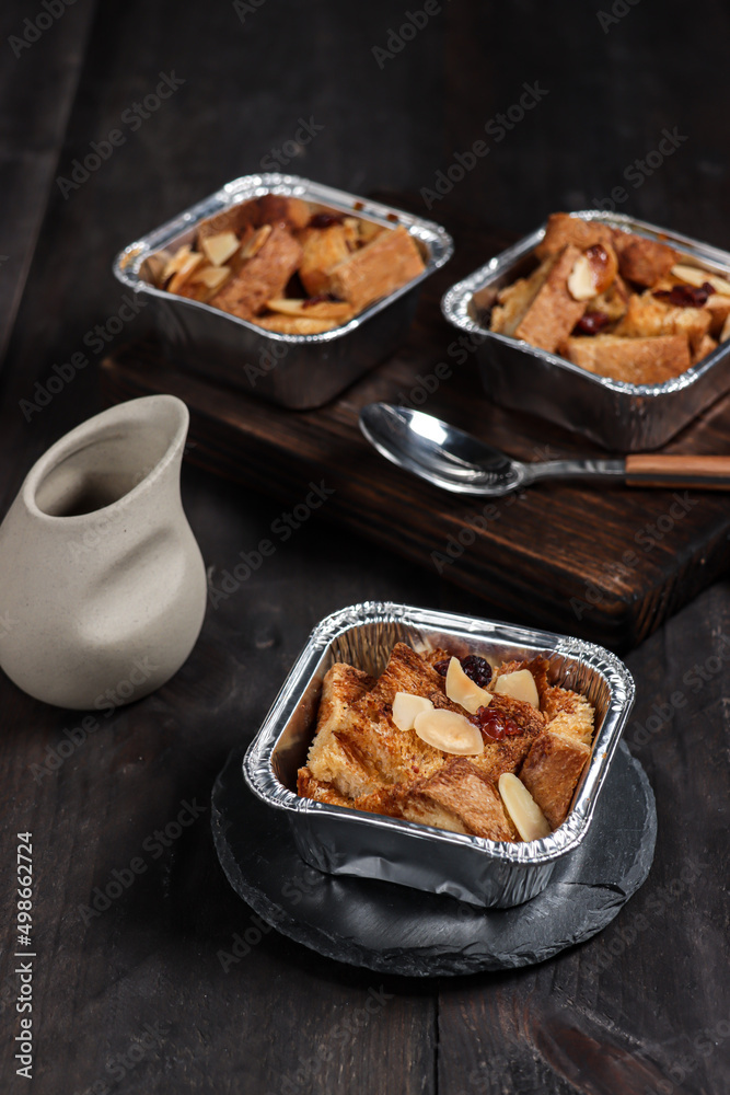 Bread pudding or puding roti tawar topping with almond slice and dried cranberry.