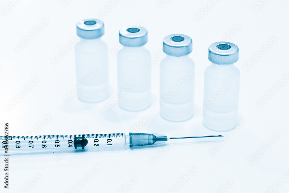 Vial of Drugs and 1 ml Plastic Syringe with Needle Isolated on the White Background Vial of Drugs and 1 ml Plastic Syringe with Needle Isolated on the White Background
