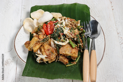 Lotek is an Indonesian traditional salad, consist of vegetable, ketupat, bakwan and crackers with sweet and spicy taste peanuts sauce. photo