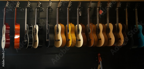 classic guitar drapped in a row in a huge musical shop, instrument shop, instrument concept