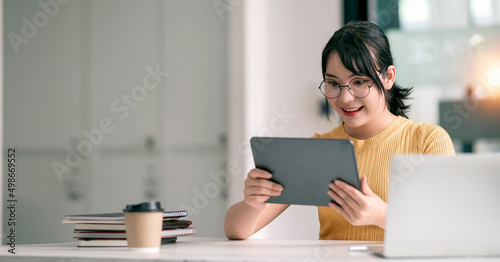 Foto Optimistic excited asian female holding tablet feeling euphoric celebrating with success achievement result, great offer or new opportunity, passed exam, got a job