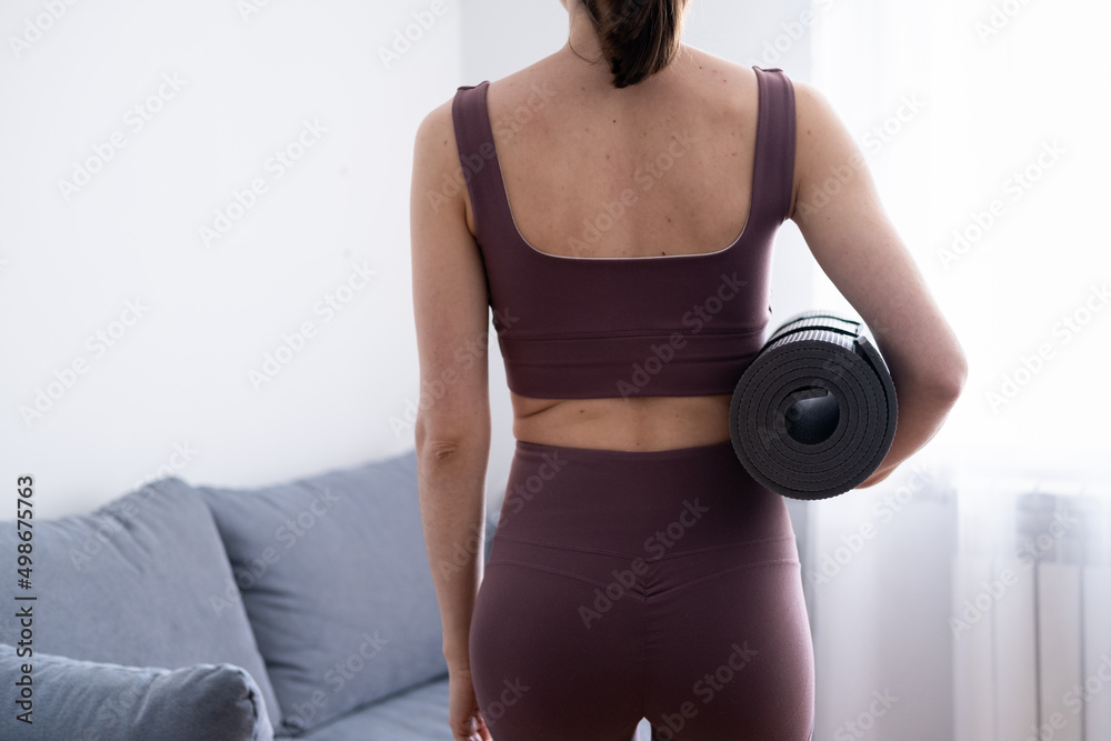 The concept of a healthy lifestyle. Workouts at home. A slender young girl does yoga, meditation, keeps her body in shape The concept of a healthy lifestyle. Workouts at home. A slender young girl does yoga, meditation, keeps her body in shape