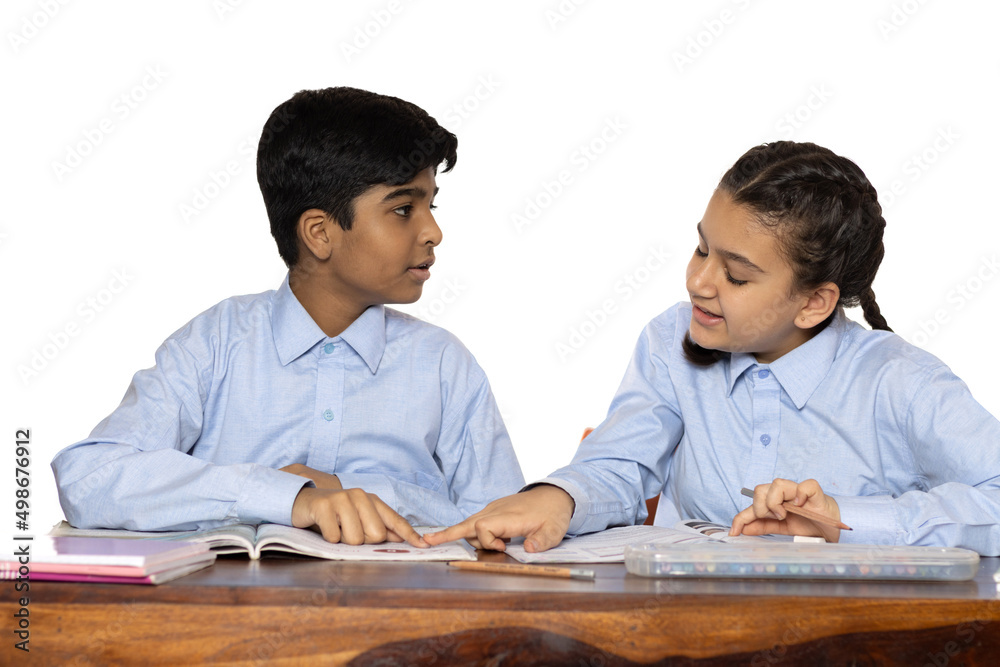 young girl and boy from primary school study in the classroom isolated on the white background young girl and boy from primary school study in the classroom isolated on the white background