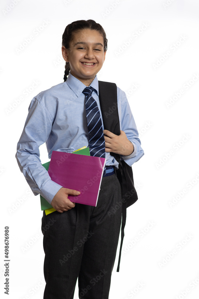young girl from primary school standing walking in the school holding books notebook and school bag isolated on white background