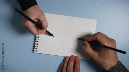 A man and a woman in a notebook perform a parkinson's disease test and hand tremor diagnosis.
