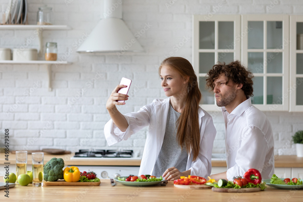 Beautiful couple spends time together at breakfast in the kitchen taking a selfie with healthy food. Beautiful couple spends time together at breakfast in the kitchen taking a selfie with healthy food.
