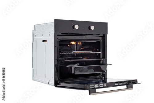 Black oven with open door and three trays, with two control knobs. with backlight on, at an angle of 45 degrees. Isolate on white
