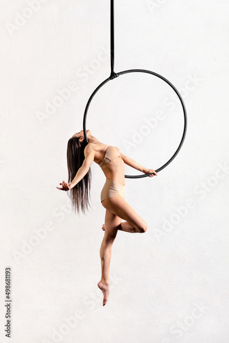 Fit woman performing pose on aerial hoop photo