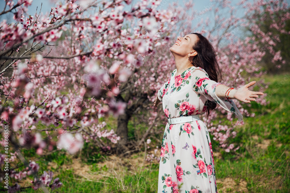 a woman in a garden of flowering trees in the spring