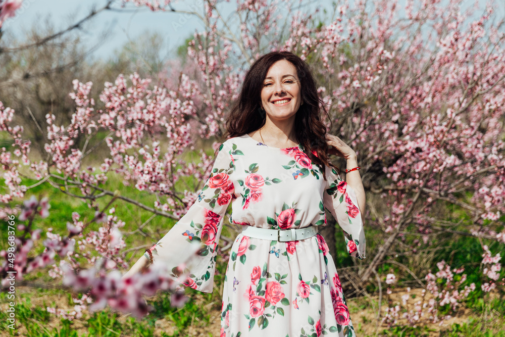 a woman in a garden of flowering trees in the spring a woman in a garden of flowering trees in the spring