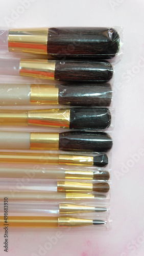 Closeup of a set of new makeup brushes in different size, still wrapped in plastic packaging.