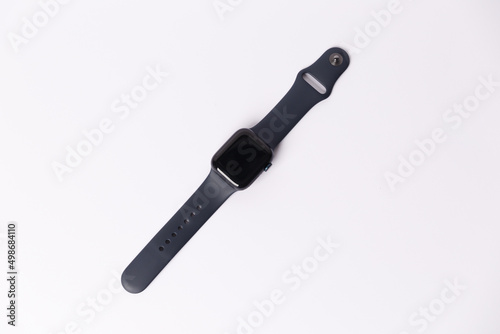 A smartwatch isolated on a white background. Black smartwatch with insulated wrist with open strap. Modern design for high-tech smartwatch and sport technology concept. Close up. Top side view.