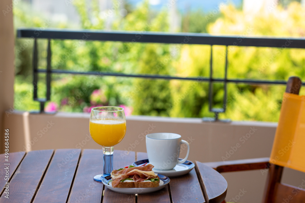 Summer. Breakfast outside by the ocean. Summer vacation in the hotel. Sandwich with coffee and orange juice. Breakfast outside in front of the ocean. Dinner. Food at the hotel. Vacation for one. Food 