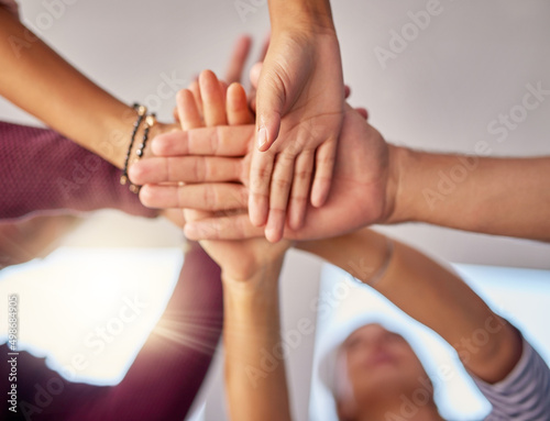 Theyre a handy bunch of businesspeople. Cropped shot of a group of unrecognizable businesspeople piling their hands on top of each other in the office.