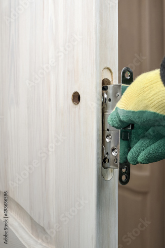 Installing a lock on a wooden door. Door lock repair and replacement. Installation and insertion lock in a wooden door.