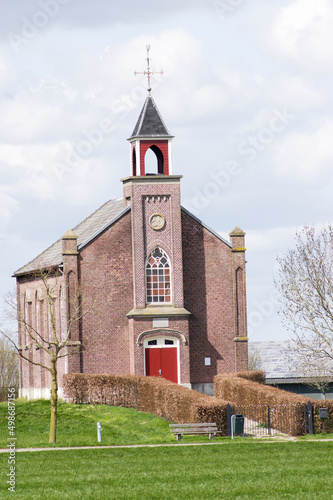 The front of a facade of a small church in dutch village, Homoet in the Netherlands photo