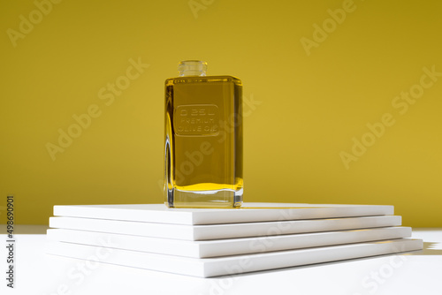 Glass of olive oil in stylish studio photo