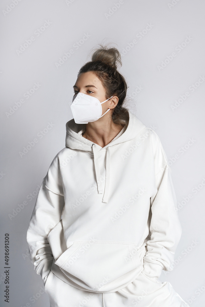 Young woman wearing white hoodie and ffp2 respirator mask Young woman wearing white hoodie and ffp2 respirator mask